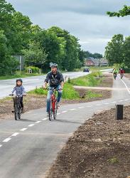 Foto af far og datter, der cykler på en dobbeltrettet cykelsti langs hovedvejen mellem Grimstrup og Endrup. 
